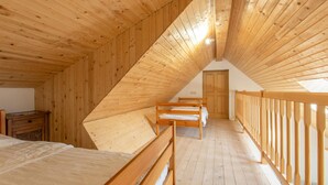 Un dormitorio abuhardinado con camas literas, un escritorio y una puerta que da a otra habitación.