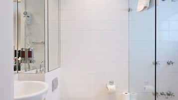 A modern bathroom with a glass-enclosed shower, a white sink, and a toilet.