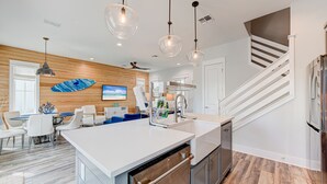 A modern kitchen with a central island, stainless steel appliances, and pendant lighting. - Resort Pools, Golf Cart Boardwalk to Beach, Pet Friendly (Port Aransas)
