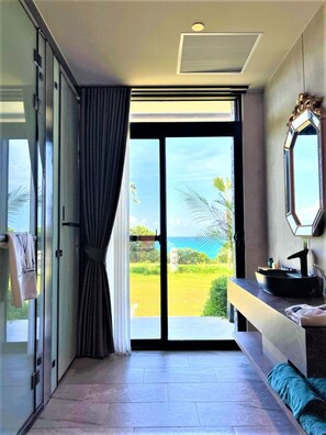 A modern bathroom with a large sliding glass door leading to a balcony with a view of the ocean. - Kenting Sand Island W-Villa Seaview Resort (Hengchun)