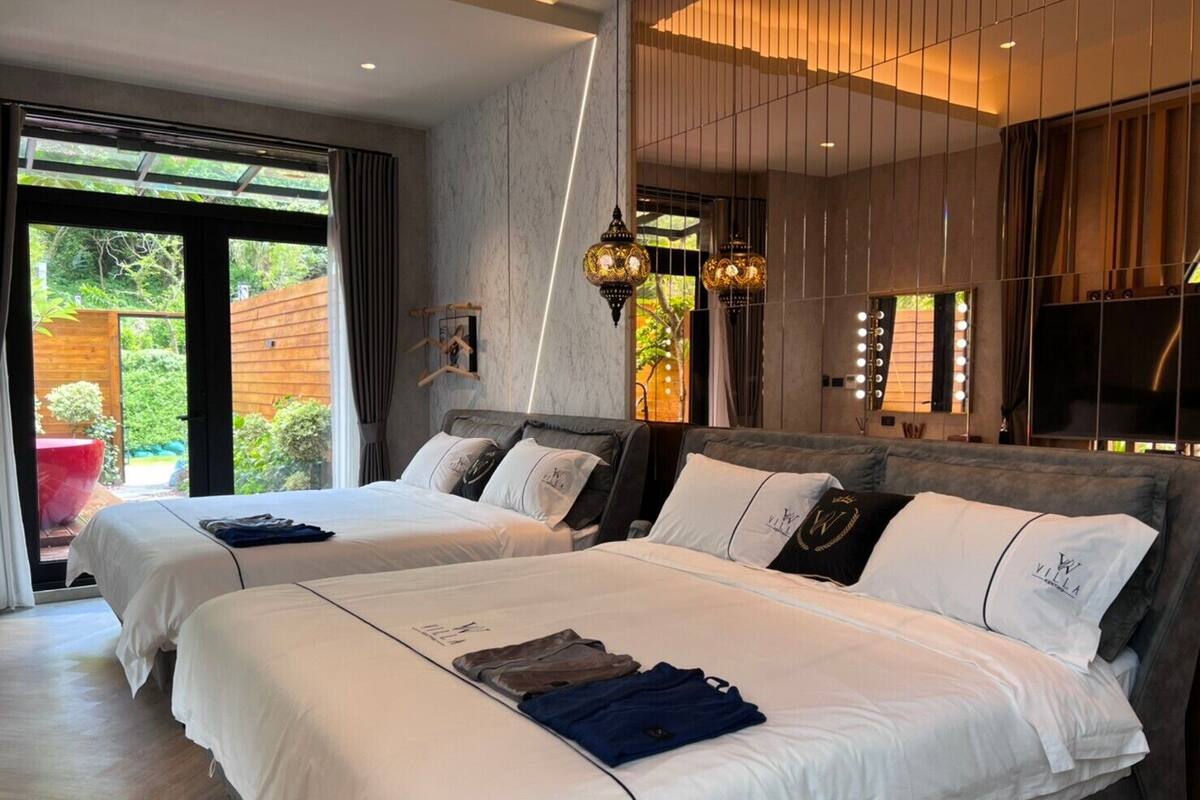 A modern hotel room with two beds, a large window, and a balcony.