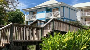 A two-story building with balconies and a wooden deck.