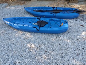 Due kayak blu su un fondo di ghiaia.