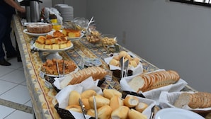 A buffet table with various food items including cakes, pastries, and bread. - Vilhar Palace Hotel (Ivaipora)