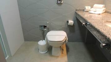 Un baño pequeño con inodoro, bidé y lavamanos.