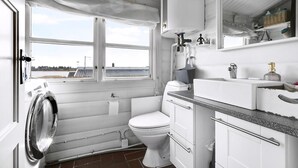 Un baño pequeño con inodoro, lavabo y lavadora.