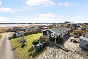 Un barrio residencial con casas, un camino de entrada pavimentado y un extenso campo abierto al fondo.