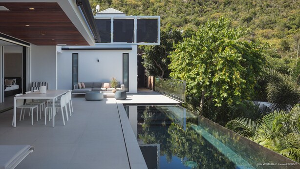 A modern villa with a glass infinity pool, outdoor seating, and a view of a lush hillside. - Villa Ventura | Ocean View - Located in  Magnificent Lurin with Private Pool (Lurin)