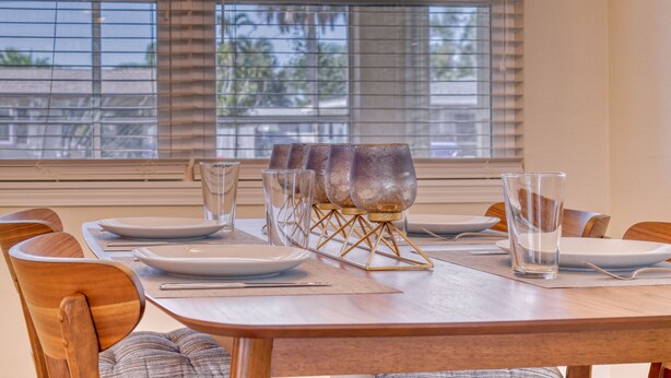 Une table à manger dressée avec des assiettes, des verres et un joli porte-verres décoratif.