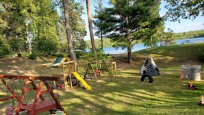 A playground with swings, slides, and a small castle-like structure.