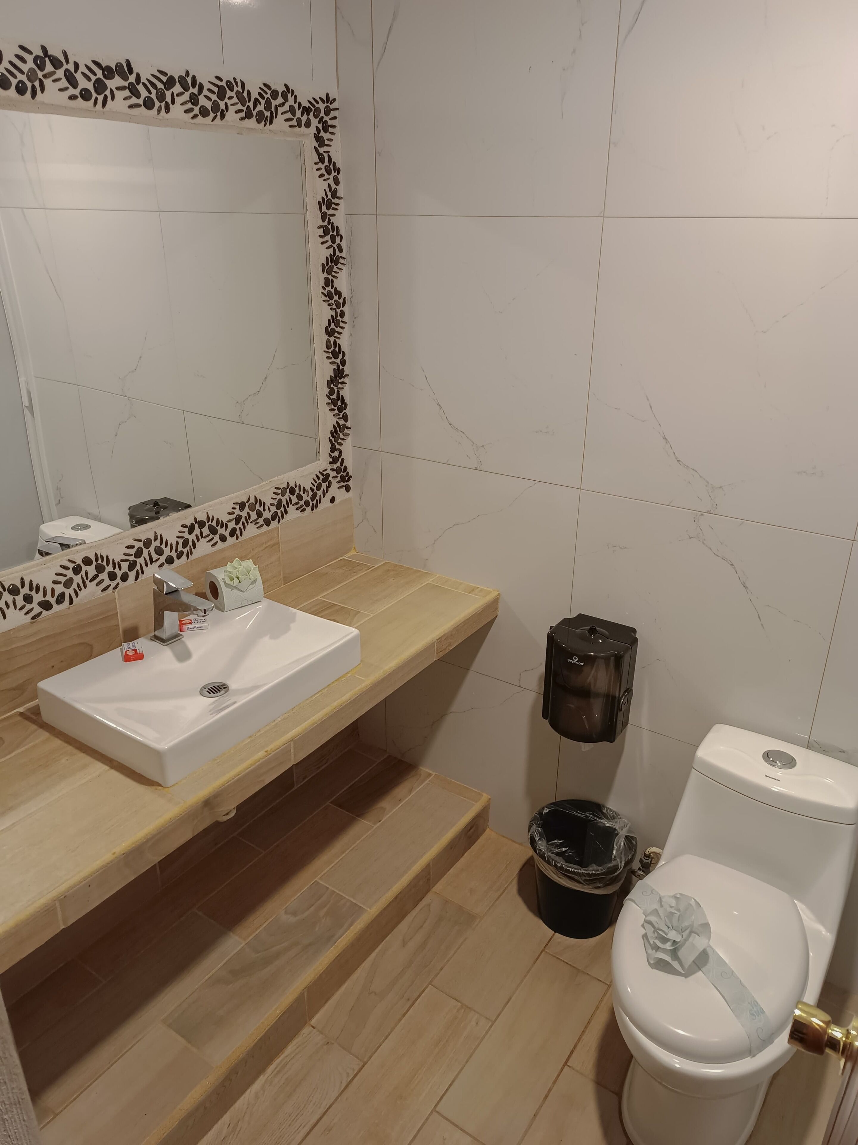 Ein Badezimmer mit Waschbecken, Spiegel und Toilette.
