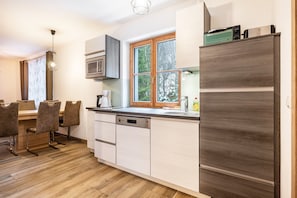Una cocina moderna con lavavajillas, microondas y un refrigerador grande.