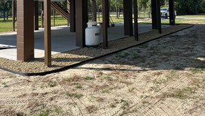 A two-story house with a covered patio area, a large water heater, and a garage. - New riverfront home across from Rock Bluff Springs on the Suwannee river (Branford)