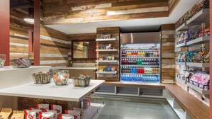 A grocery store interior with wooden panel walls, a central aisle, and shelves stocked with various products. - King Room at a 4⭐️ Hotel (Nashville)