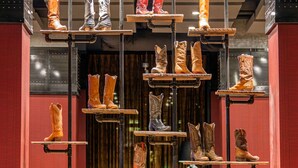 Verschiedene Stiefel hängen an Metallregalen.