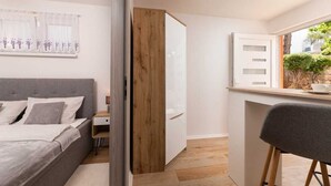 Ein modernes Schlafzimmer mit einem Bett, einem Nachttisch und einem Fenster mit Vorhängen.