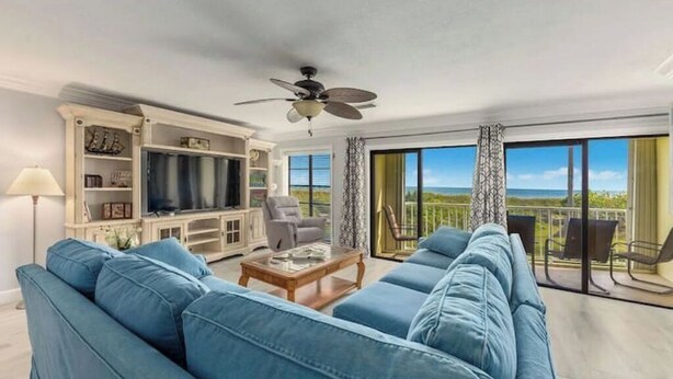 Una sala de estar con sofá, televisor y balcón con vistas.