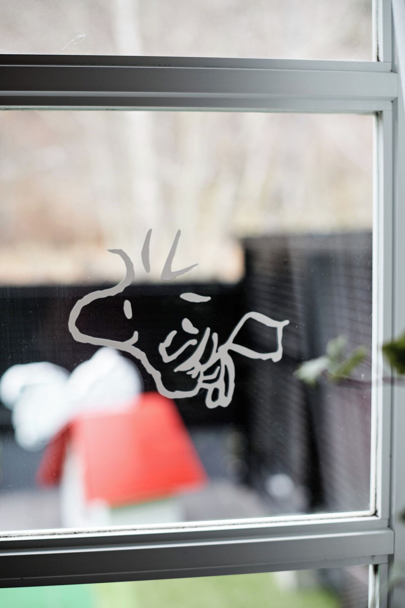 A window with a black and white cow sticker.