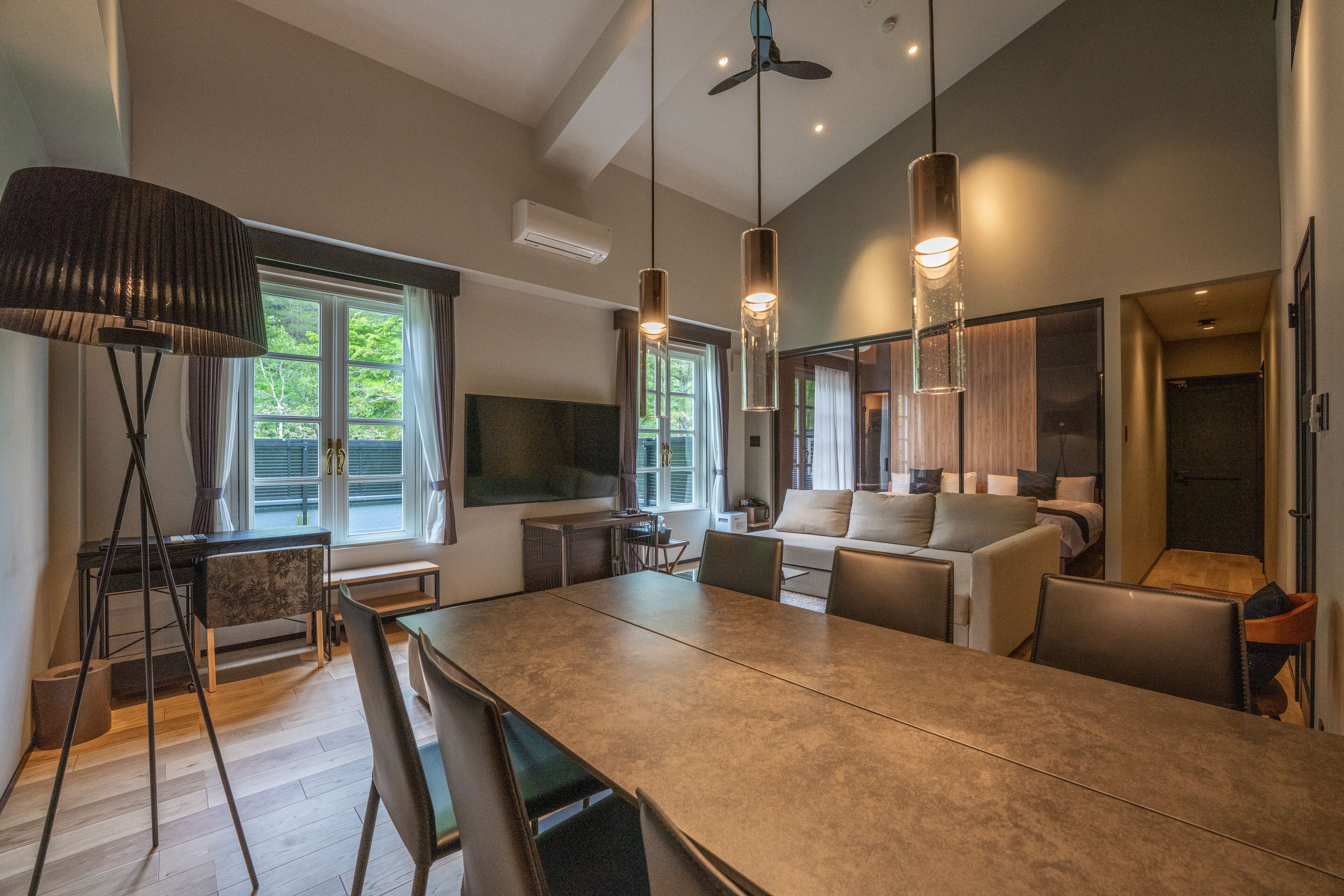 A modern kitchen with a large island, pendant lighting, and a view of the outdoors.