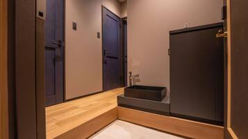 Un baño moderno con un tocador de madera, un mueble oscuro y un lavabo.