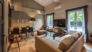 A modern living room with a sofa, coffee table, and dining area. - eau sol vert karuizawa club (Karuizawa)