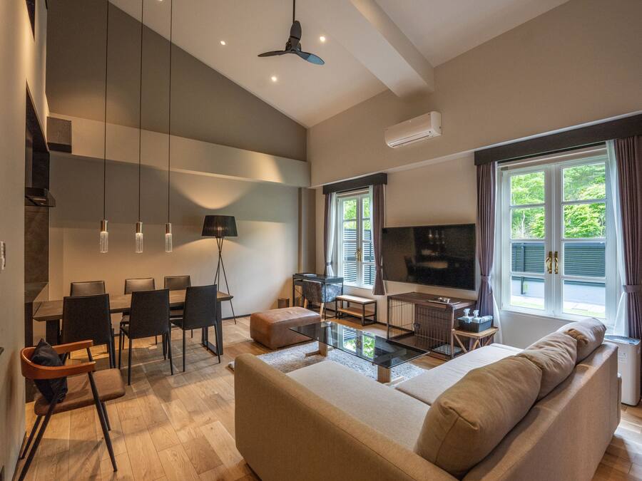 A modern living room with a sofa, coffee table, and dining area.