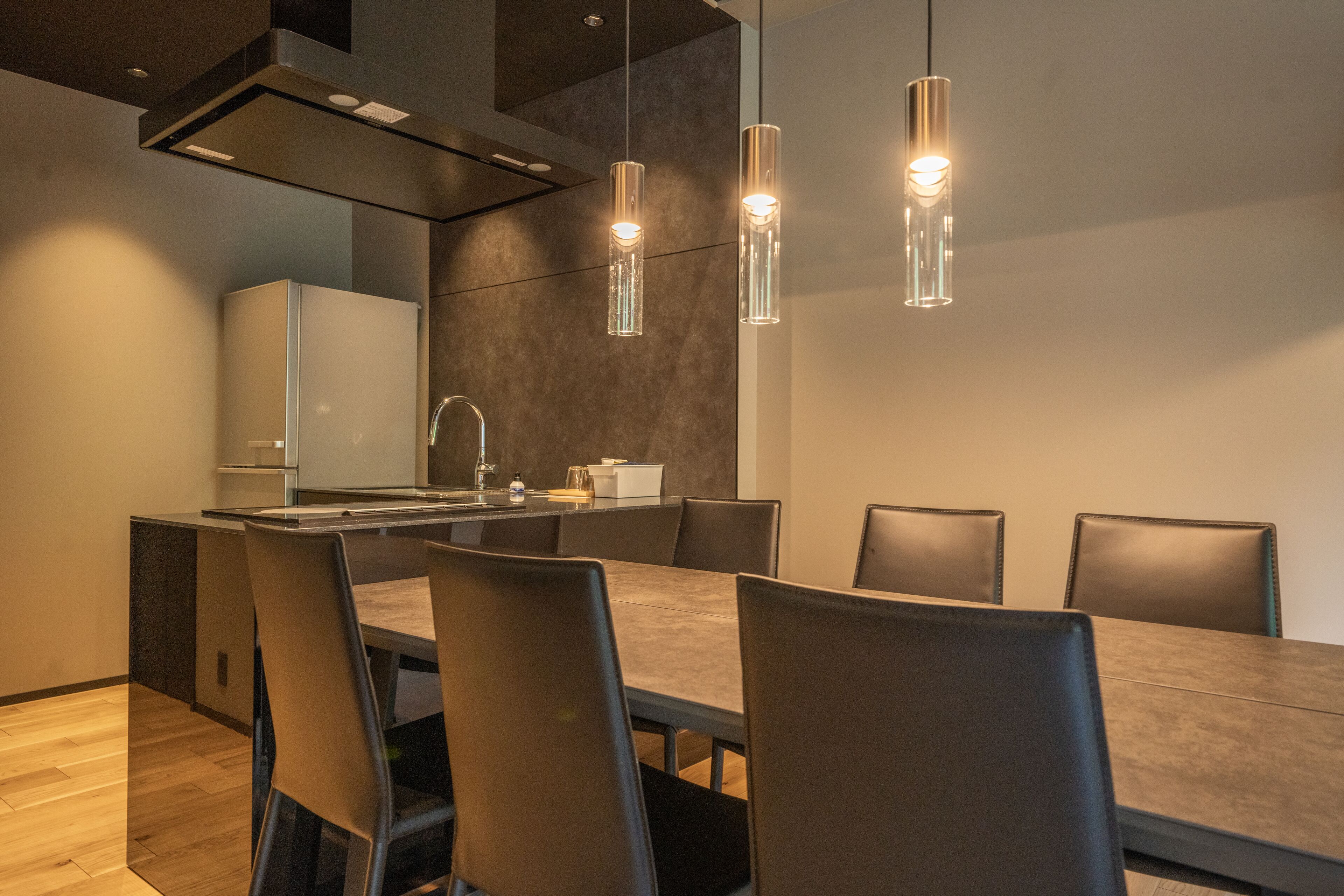 A modern kitchen with a central island, stainless steel appliances, and pendant lighting.
