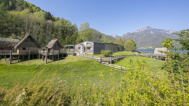 A traditional wooden house with a thatched roof, a modern building with large windows, and a wooden deck overlooking a lake with mountains in the background. - Casa Gioiosa, Ledro, Italy (Ledro)
