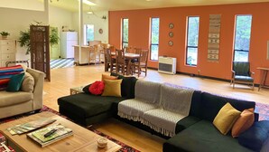 A spacious living room with a sofa, coffee table, and a dining area with chairs and a table.