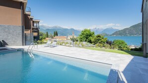 Una piscina con vistas a montañas y un lago.