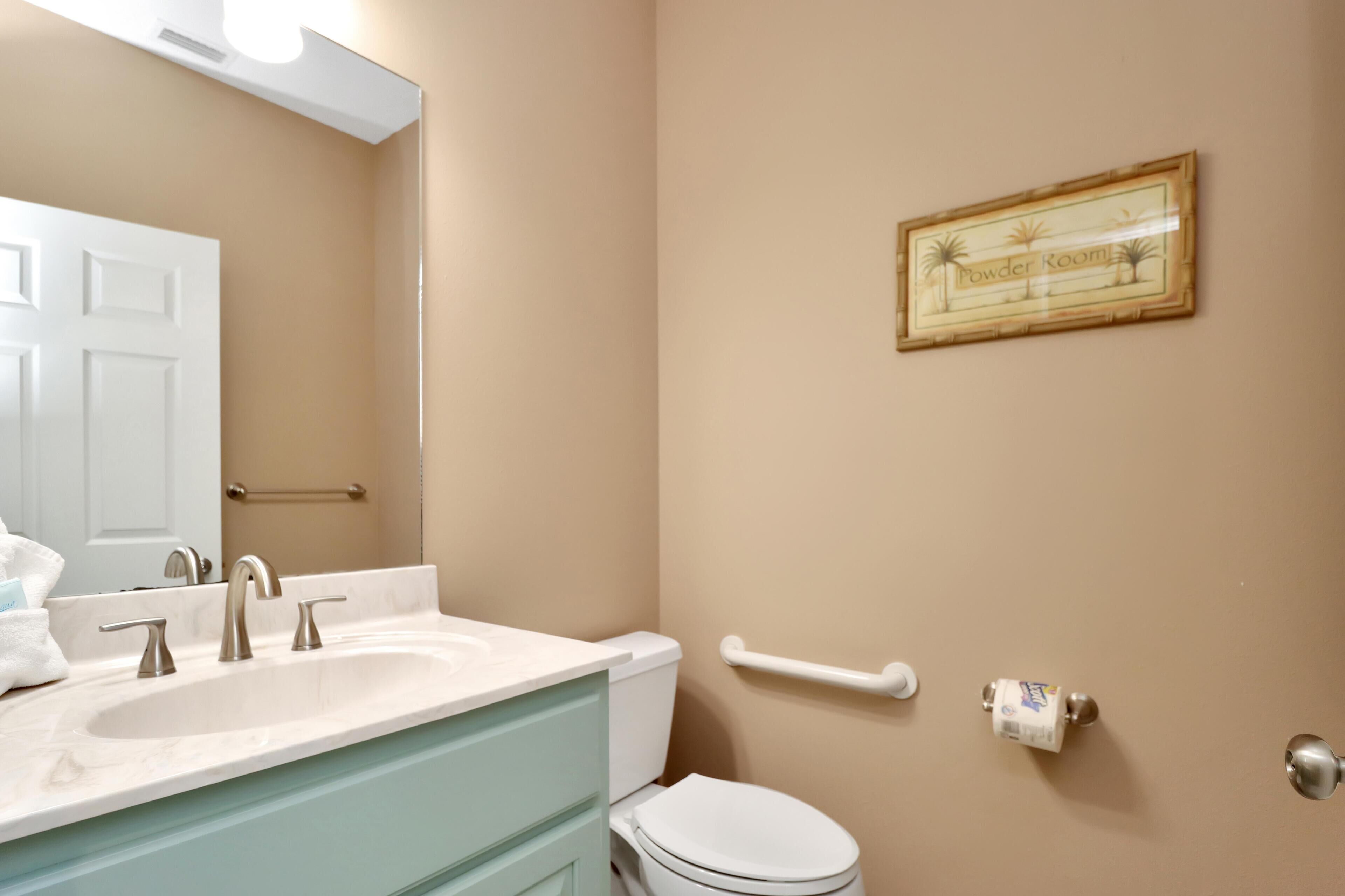 A bathroom with a white sink, a toilet, and a towel rack.