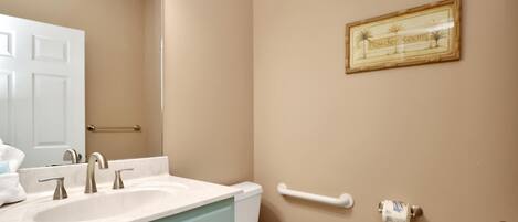 A bathroom with a white sink, a toilet, and a towel rack.