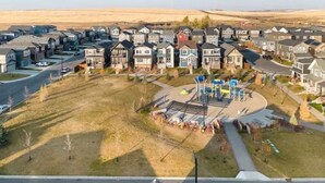 Un quartier résidentiel avec des maisons, une aire de jeux et une route.