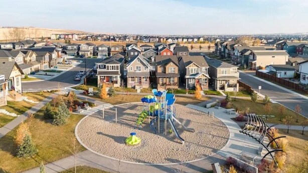 Un quartier résidentiel avec des maisons, une aire de jeux et une route.