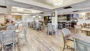 Ein geräumiges Restaurant mit hohen Decken, moderner Beleuchtung und Korbmöbeln.