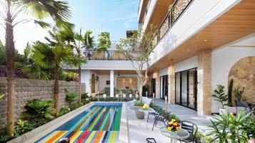 Un hotel moderno con piscina, mobiliario exterior y exuberante jardinería.