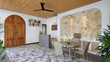 Un comedor con techo de madera, pared de piedra y alfombra estampada.