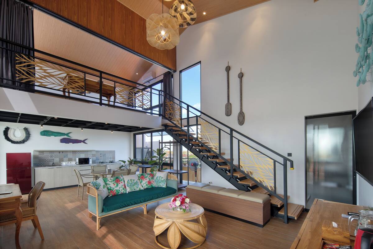 Un grand espace de vie comprenant un escalier, une cuisine et un coin repas.