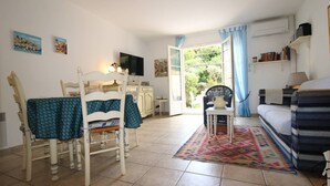 A room with a bed, a chair, a table, a television, and a view of the outdoors. - House for 4 people with air conditioning in a private domain with a pool located in Gassin (GASSIN)