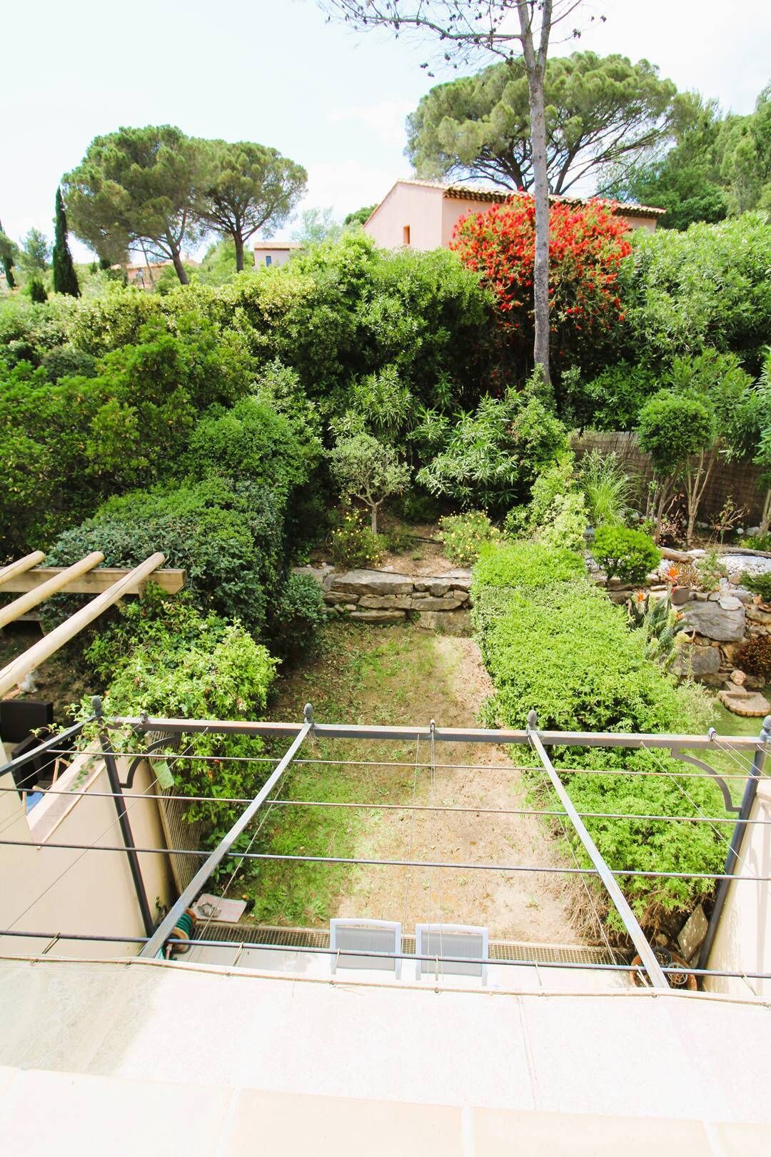 A garden with various plants and a stone wall.