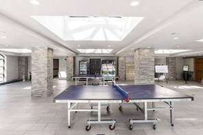 A spacious indoor area with a ping pong table, stone pillars, and a skylight. - Westgate 3603B (Park City)
