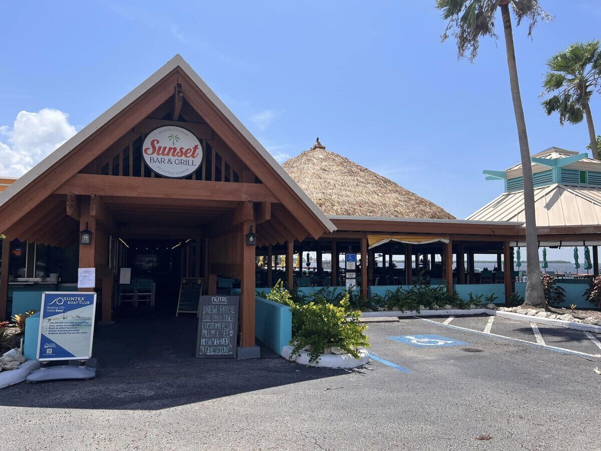 Eine Strandbar & Grill mit einem Reetdach und einem überdachten Außenbereich.