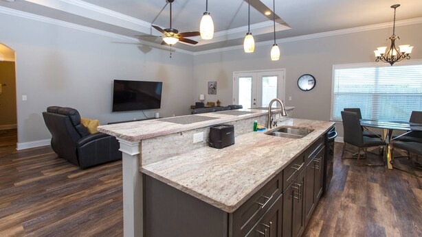 A modern kitchen with a central island, built-in appliances, and pendant lighting.