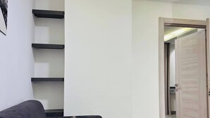 A modern living room with a dark sofa, a coffee table, and built-in shelving.