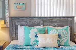 A bed with a wooden headboard, multiple pillows, and a blue bedspread.