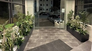 A building entrance with large windows, a tiled pathway, and potted plants. - Privet Apartment 37 for Three Near Downtown Kh&sh (Amman)