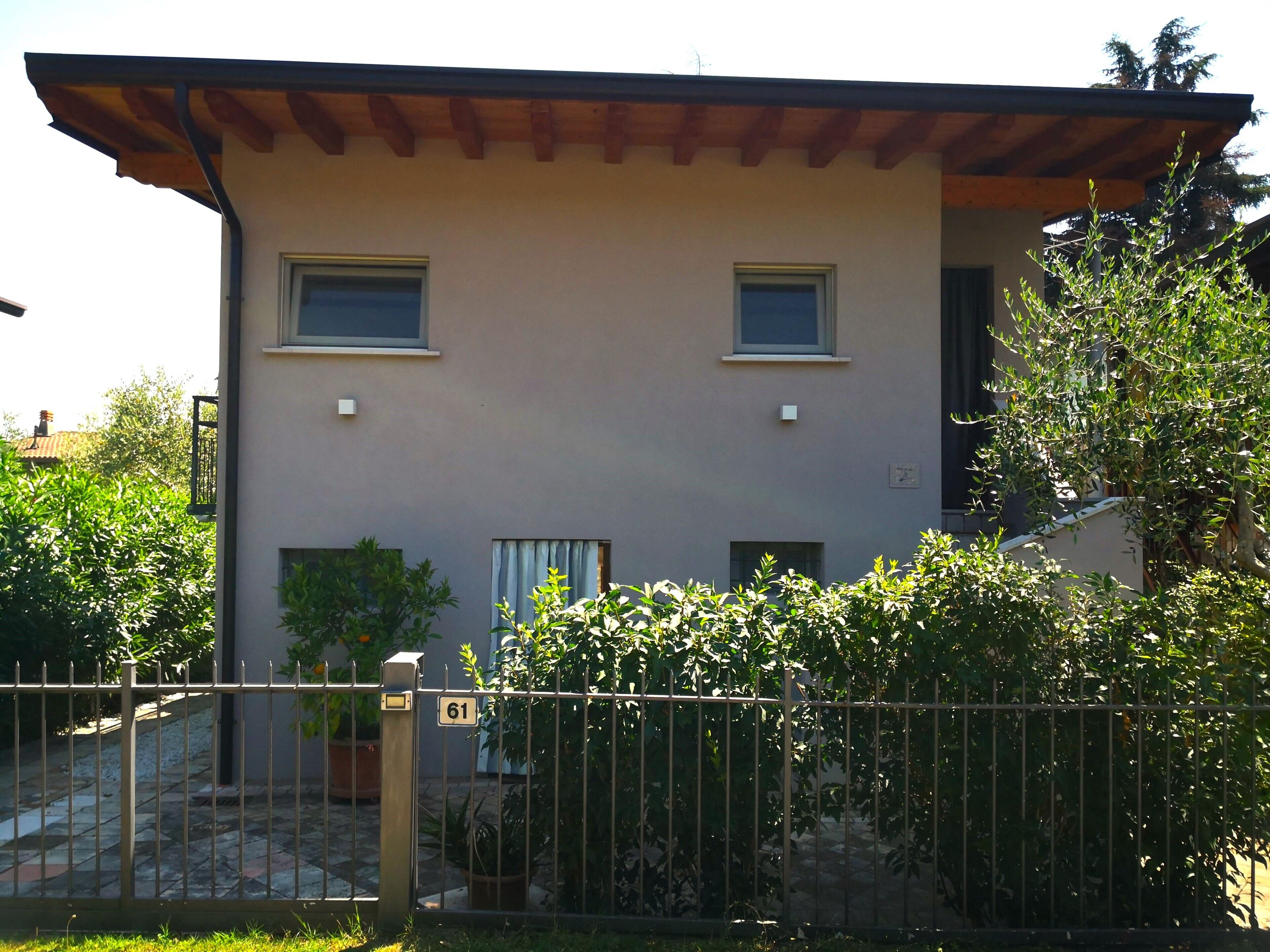 A two-story building with a flat roof, two windows on the upper floor, and a small balcony.