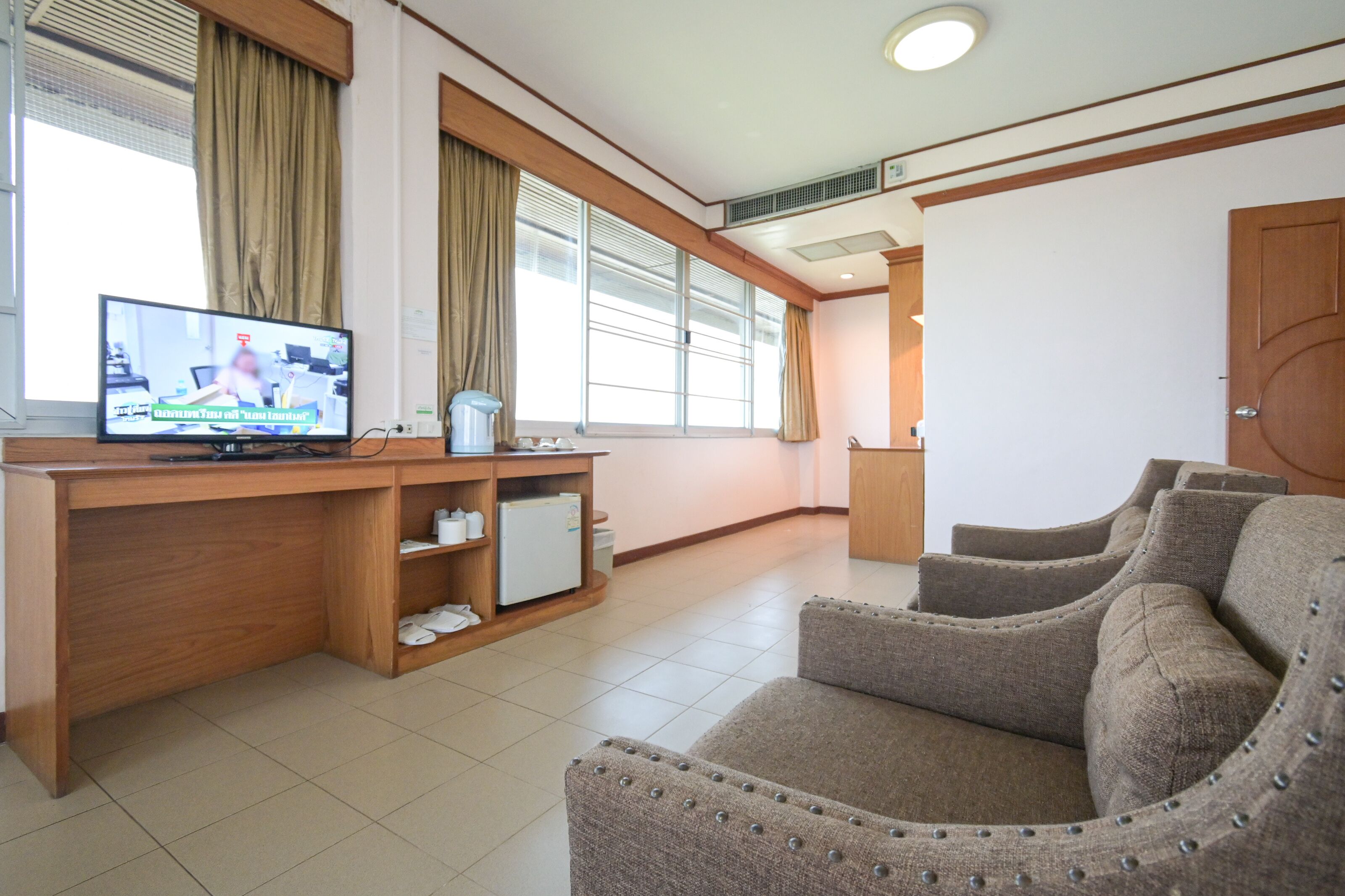 A modern living room with a wooden desk, a television, and a sofa.