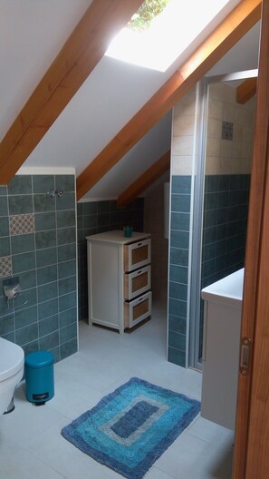 A small, compact bathroom with a skylight, a sink, a toilet, and a cabinet. - Getaway Seaside Sweet (Dubrovnik)