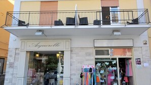 A storefront with a sign reading 'Acquerello' and a balcony above. - Central Apartment Stella House (Massa Lubrense)